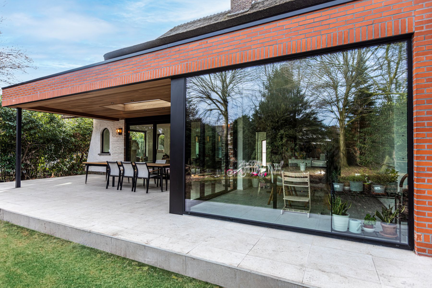 Baie coulissante aluminium anthracite ouvrant sur une terrasse couverte