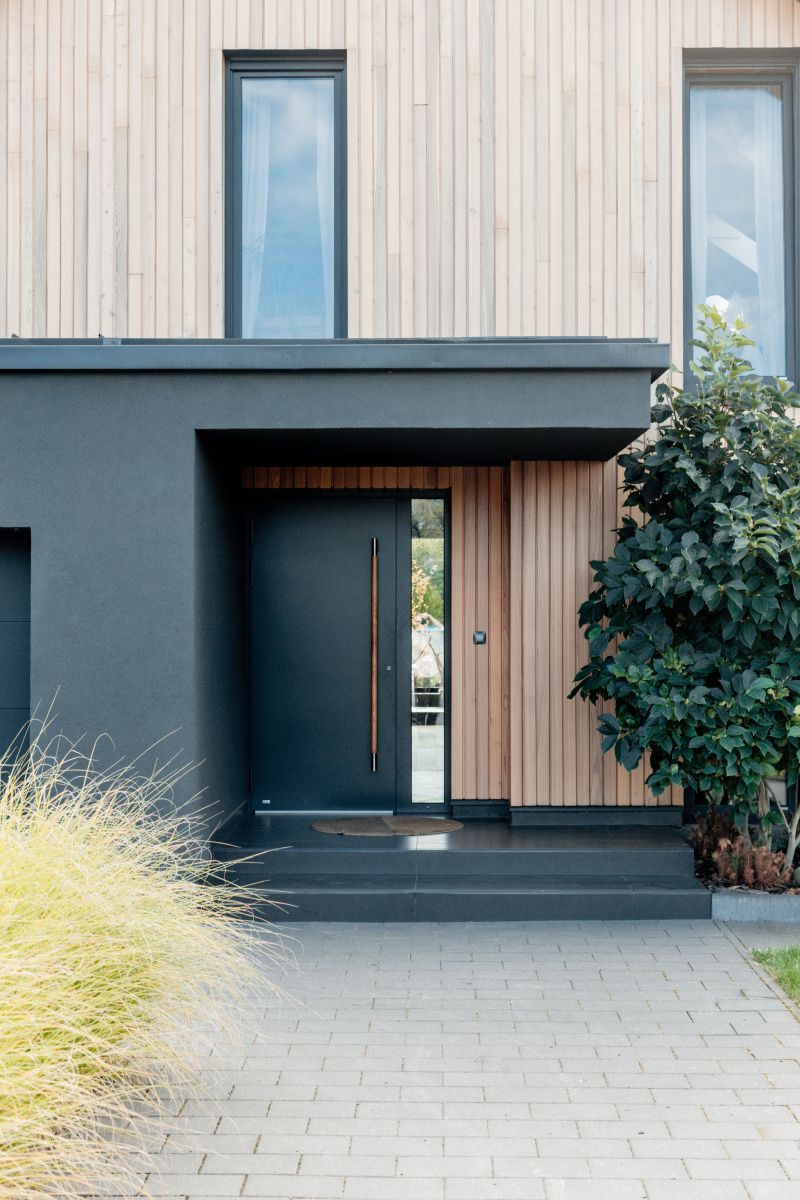 Porte d'entrée aluminium anthracite avec bardage bois sur une maison habitée