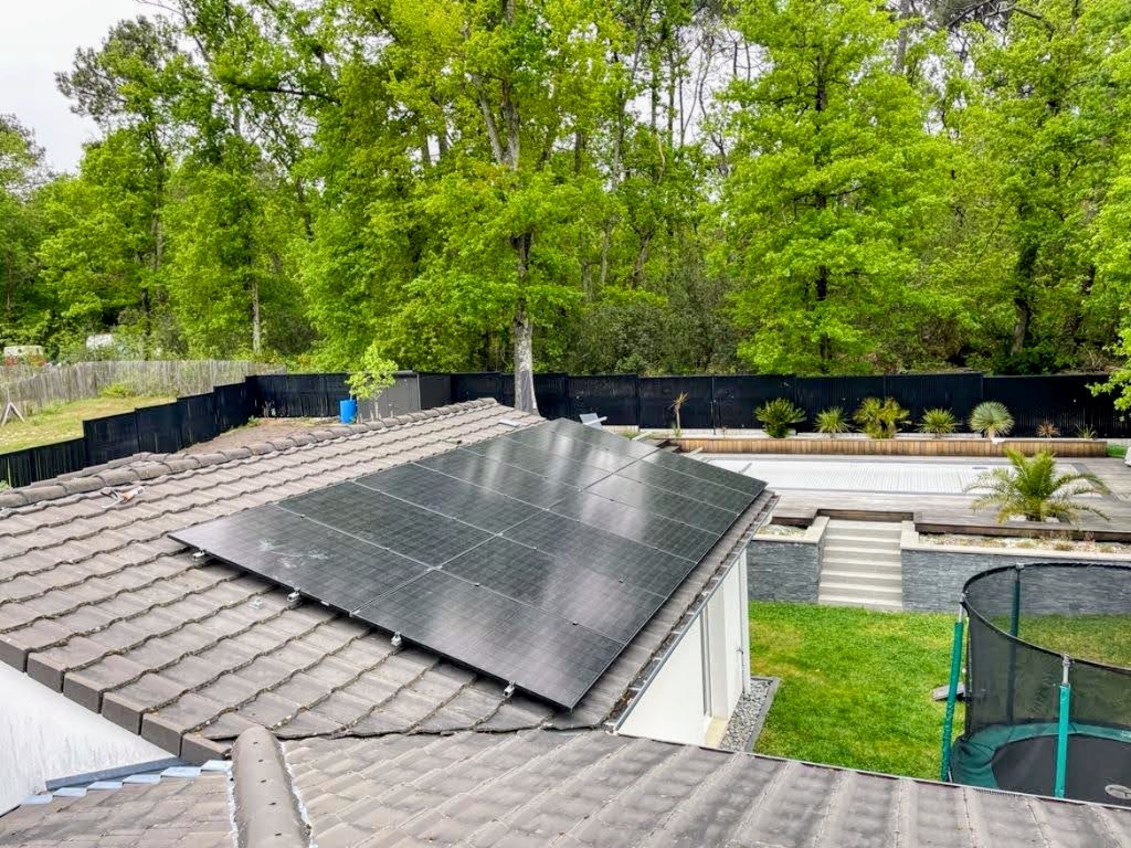 Installation photovoltaïque sur une toiture de maison contemporaine avec jardin et piscine