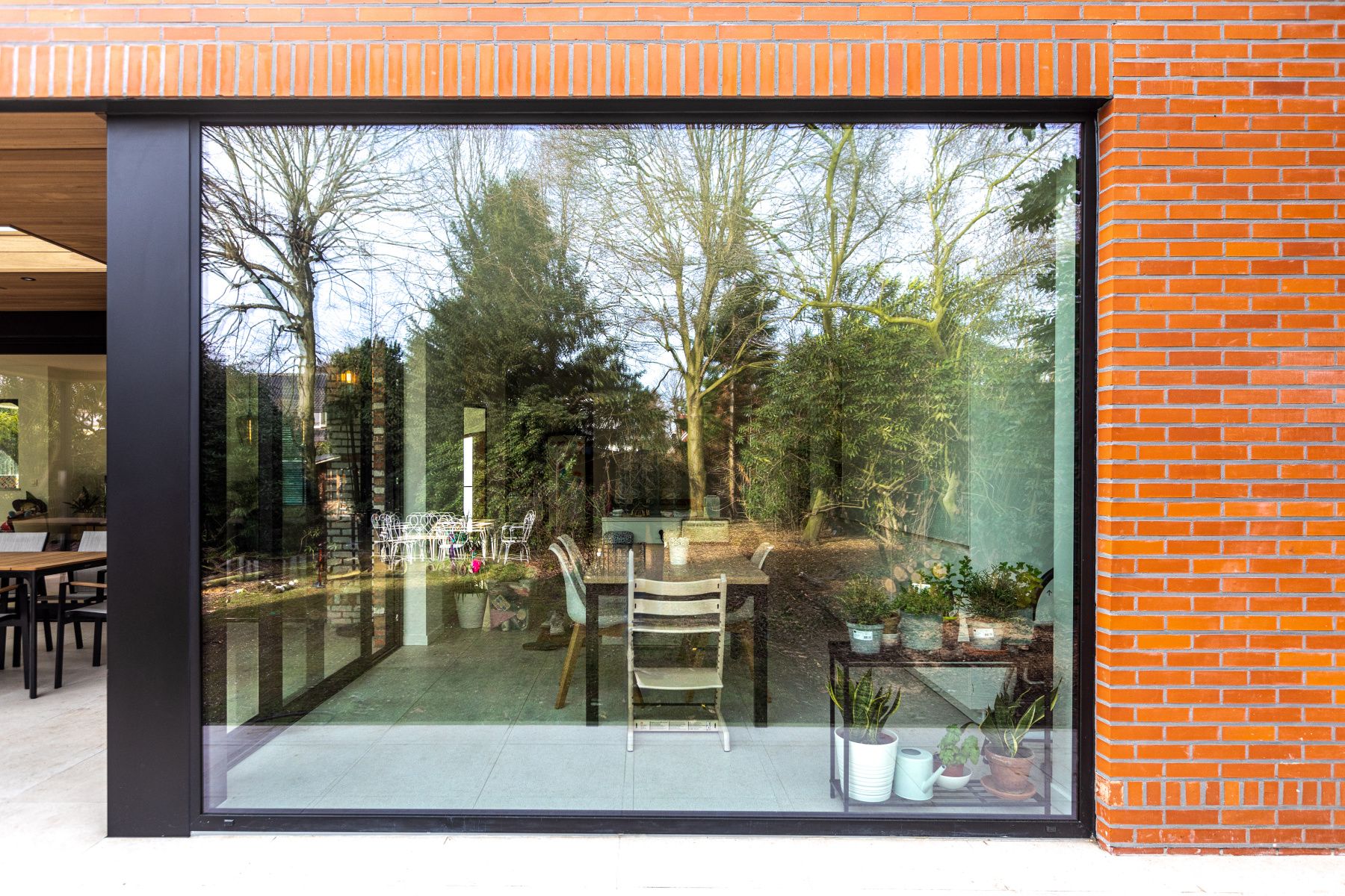 Grand châssis fixe aluminium anthracite posé sur une façade en brique